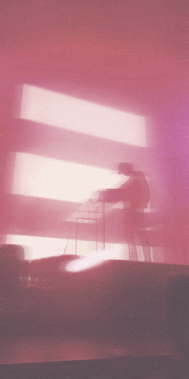 Performer silhouette against soft pink light