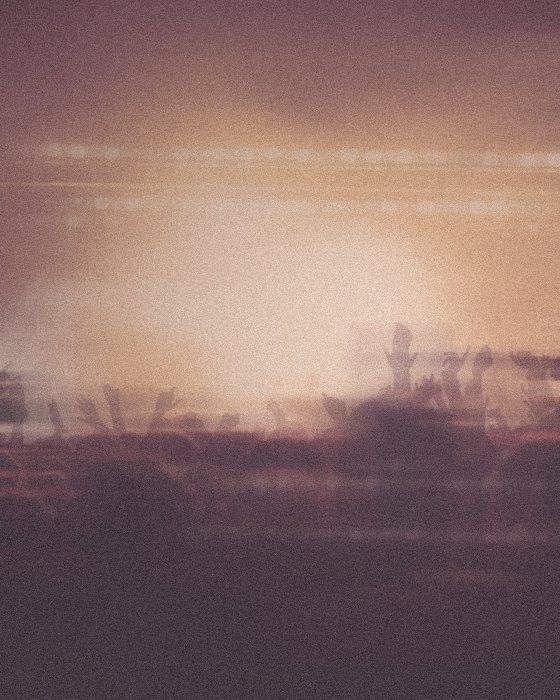 Stage lights over a crowd in a peach haze