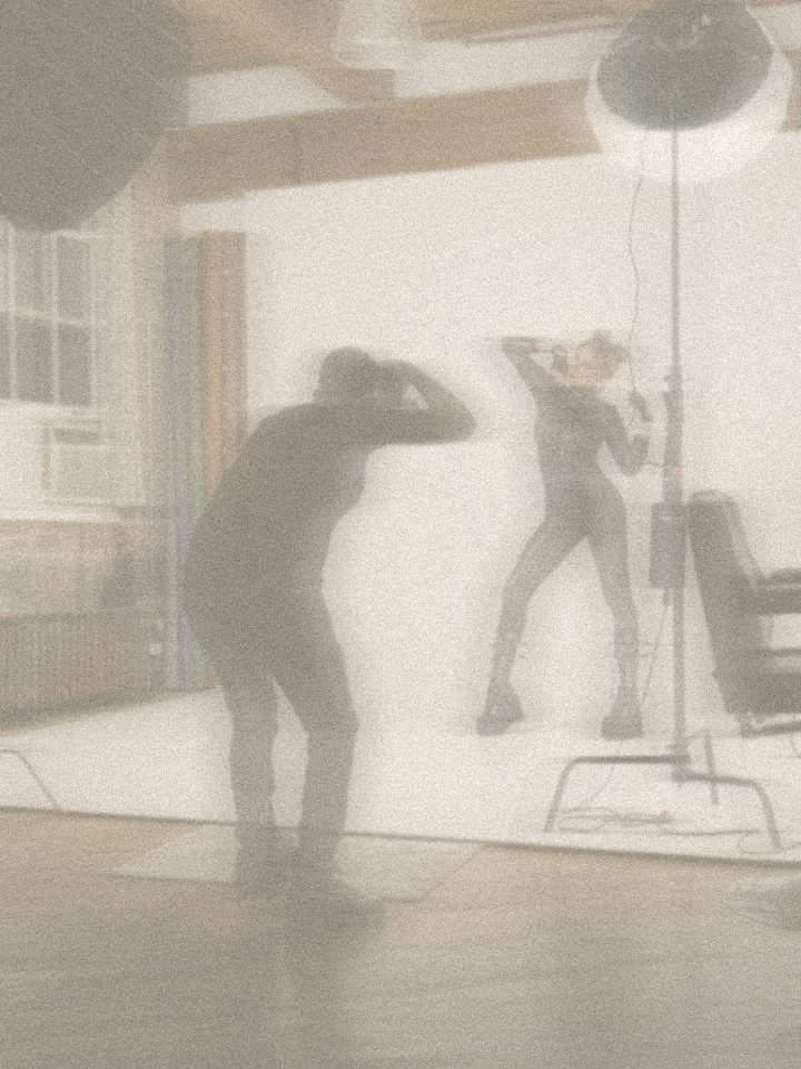 Photographer shooting a model in a cream studio